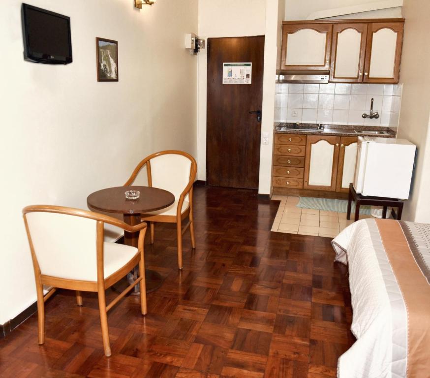 a room with a table and chairs and a kitchen at Charming studio in Funchal, 30m², city view in Funchal