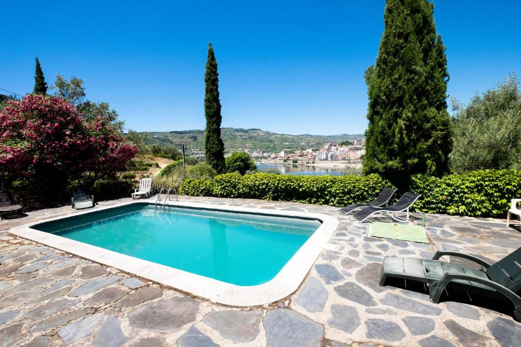 a swimming pool in a patio with chairs and trees at Charming Villa with Private Pool in Lamego in Lamego