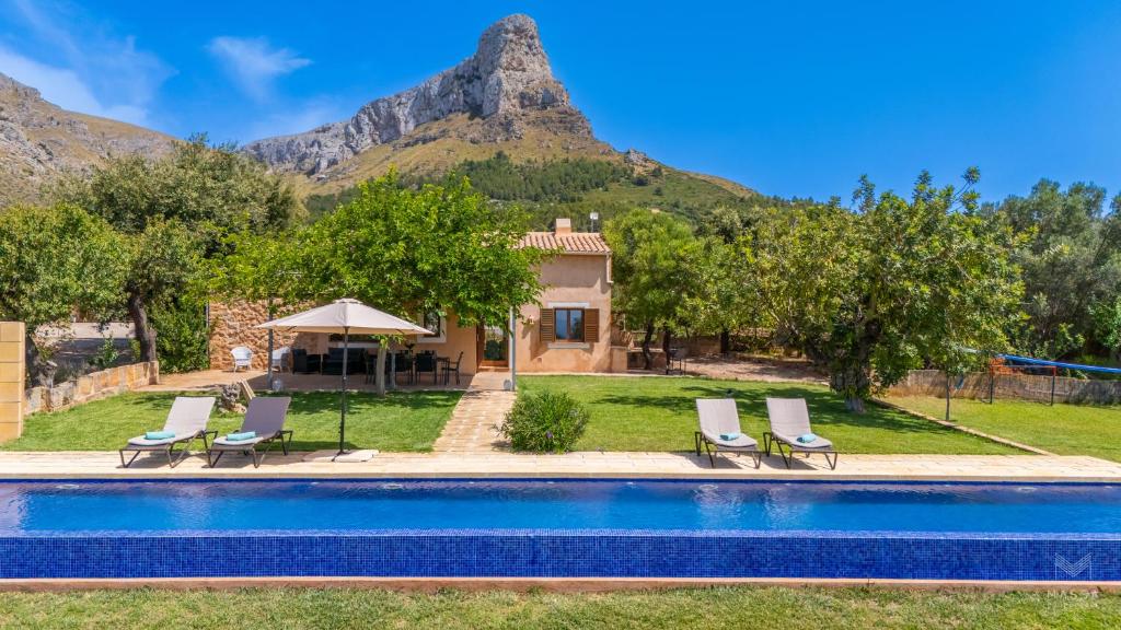 a villa with a swimming pool with mountains in the background at Finca Ca`n Jaumí, un paraíso con vista al mar y a la montaña in Artá