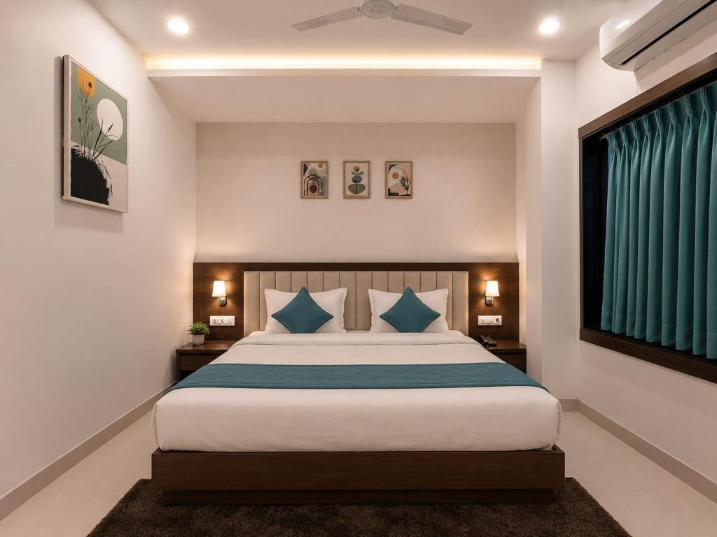 a bedroom with a large bed with blue pillows at Hotel Pride in Wardha