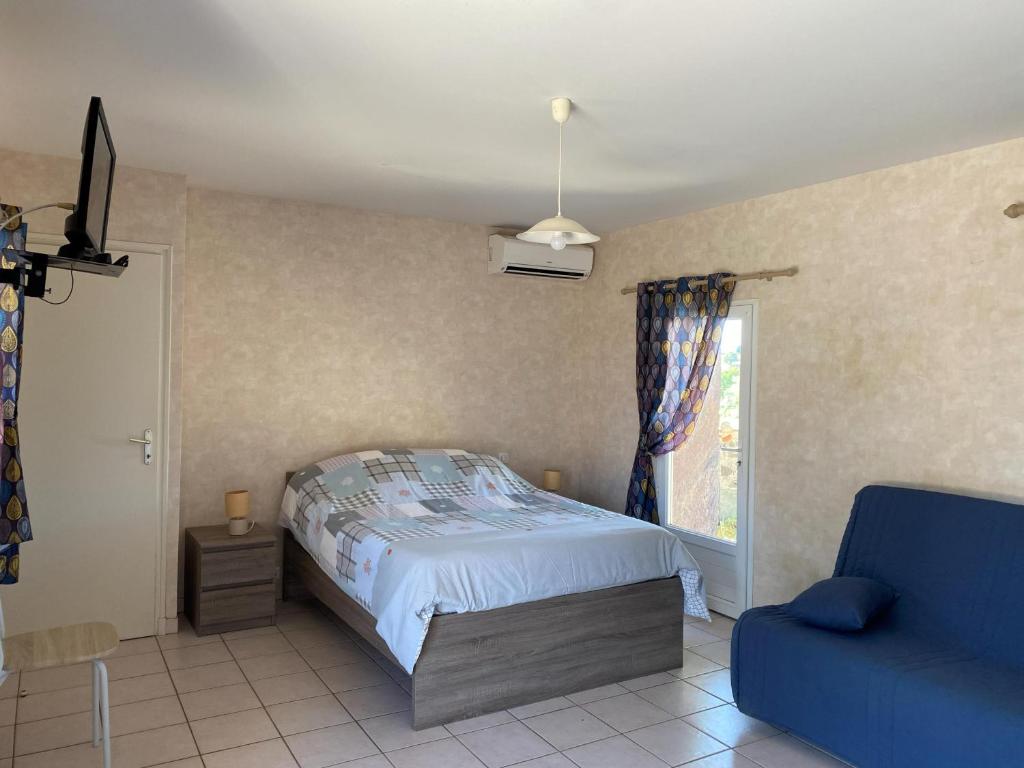 a bedroom with a bed and a blue couch at Meublé chocolat in Réaumur