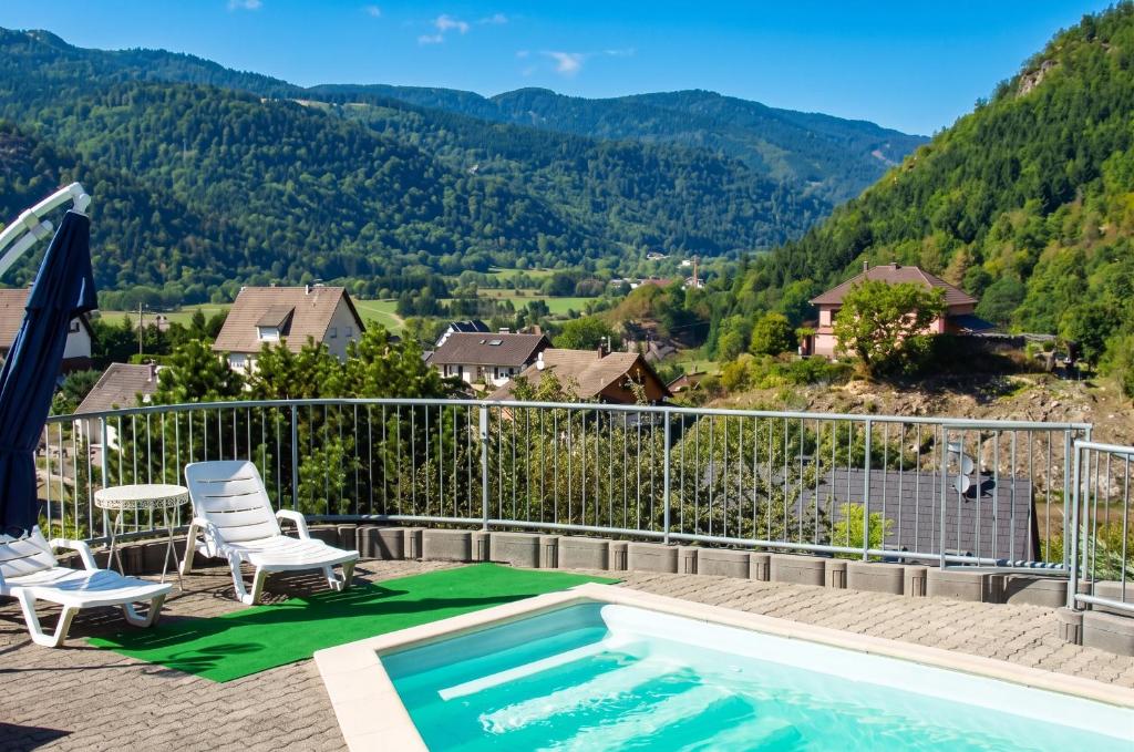 a pool on a deck with a view of the mountains at Appartement confortable à Oderen 68 m² avec piscine partagée in Oderen