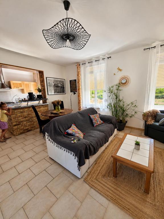a living room with a couch and a table at La maison de Victoire in Fourmies