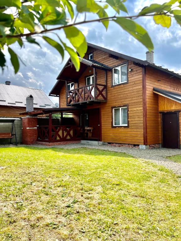 a large wooden house with a large yard at Котедж Amber in Mykulychyn