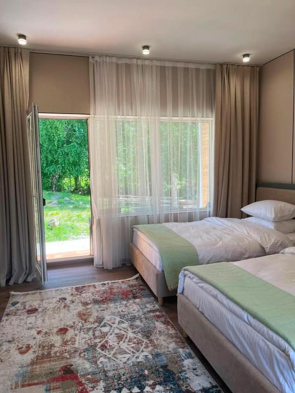 a bedroom with two beds and a large window at Алаша in Qotanqaraghay