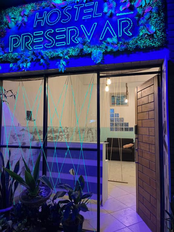 a neon sign on the front of a hospital dispensary at Preservar hostel in Cabo Frio