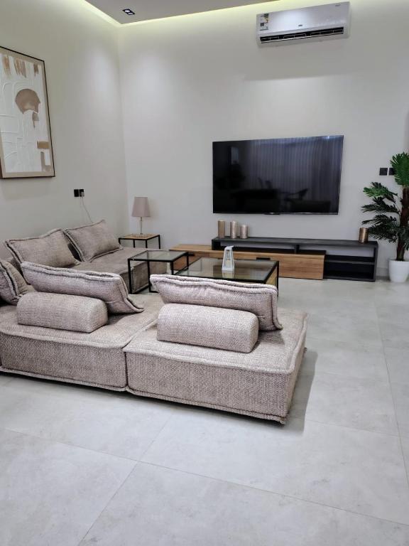 a living room with two couches and a flat screen tv at شاليهات ترف in Abha