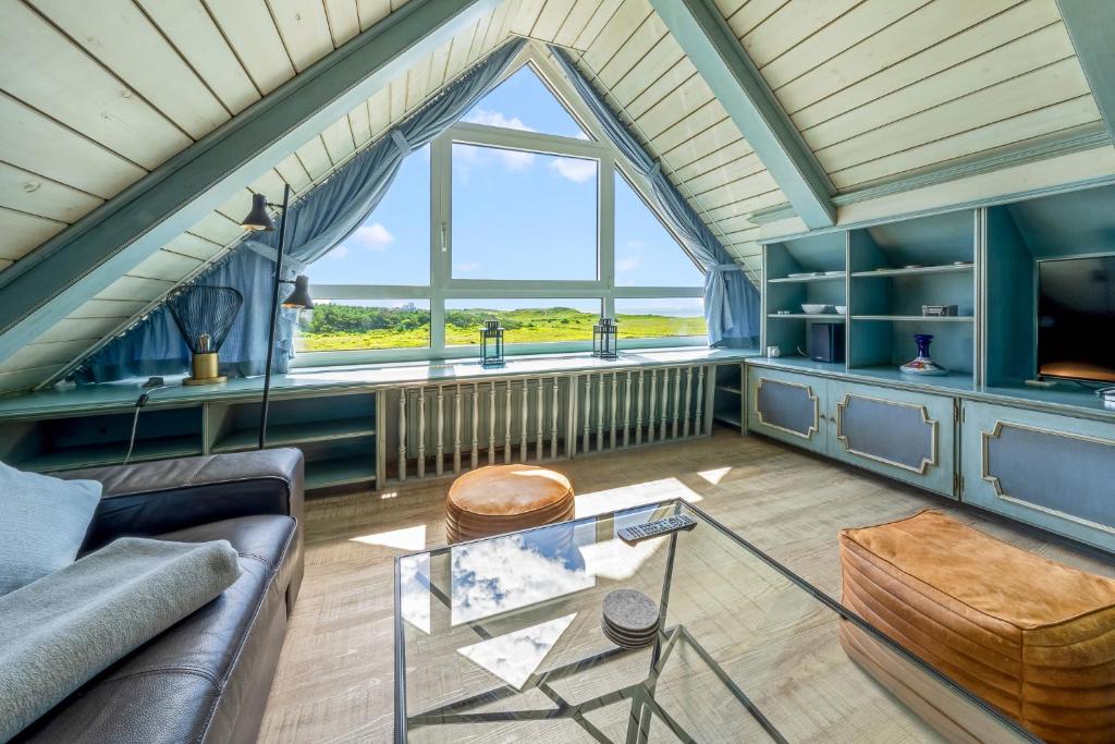 a living room with a couch and a table at Haus Fernsicht, App 4 in Wenningstedt
