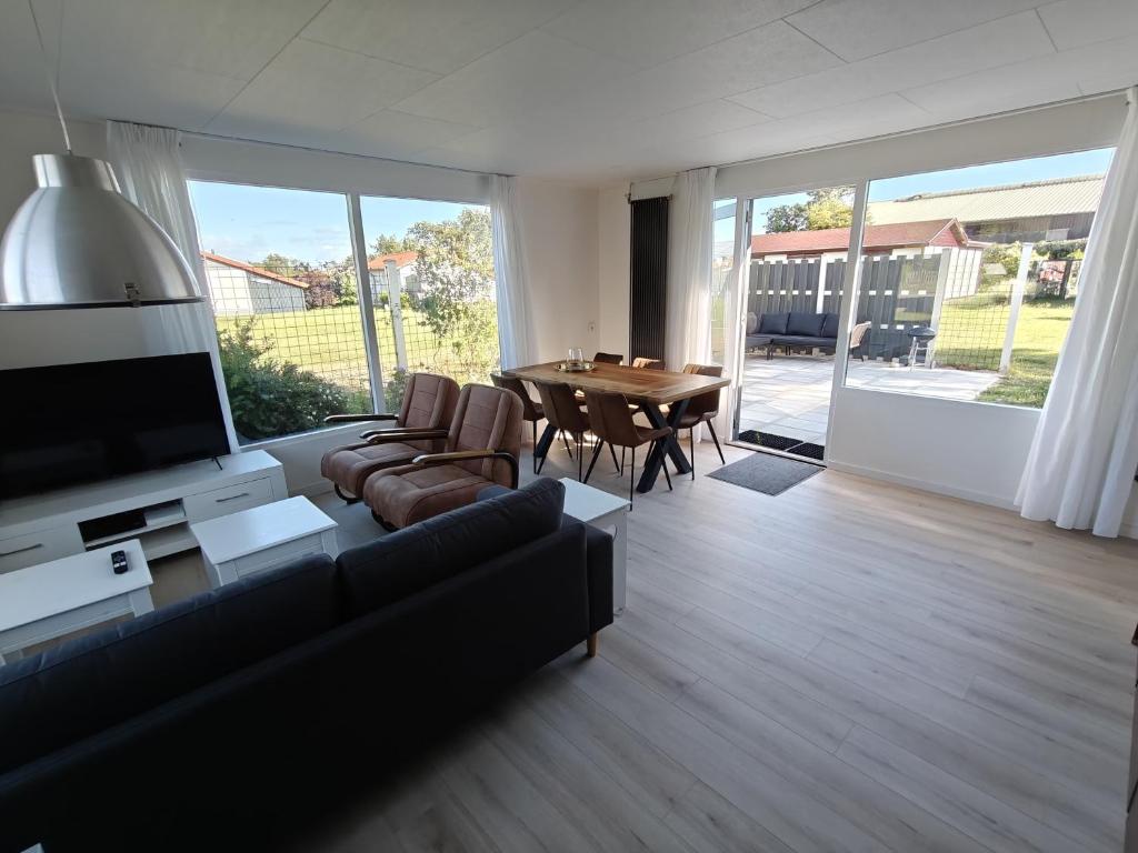 a living room with a couch and a table at Luxe 6 persoons bungalow met 3 slaapkamers 2 badkamers en ensuite ligbad in Sint Maartensvlotbrug