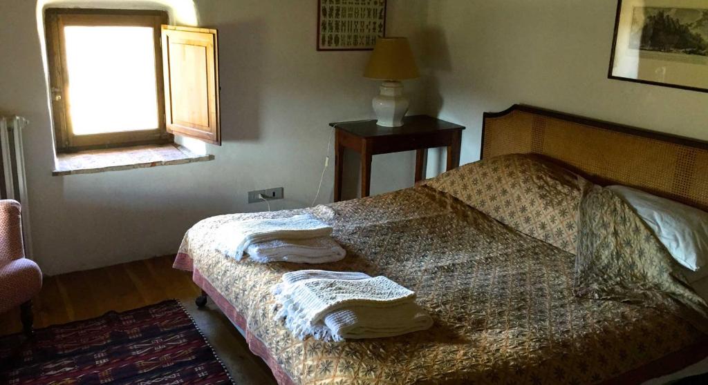 1 dormitorio con 1 cama con toallas en Castello Di Potentino en Seggiano