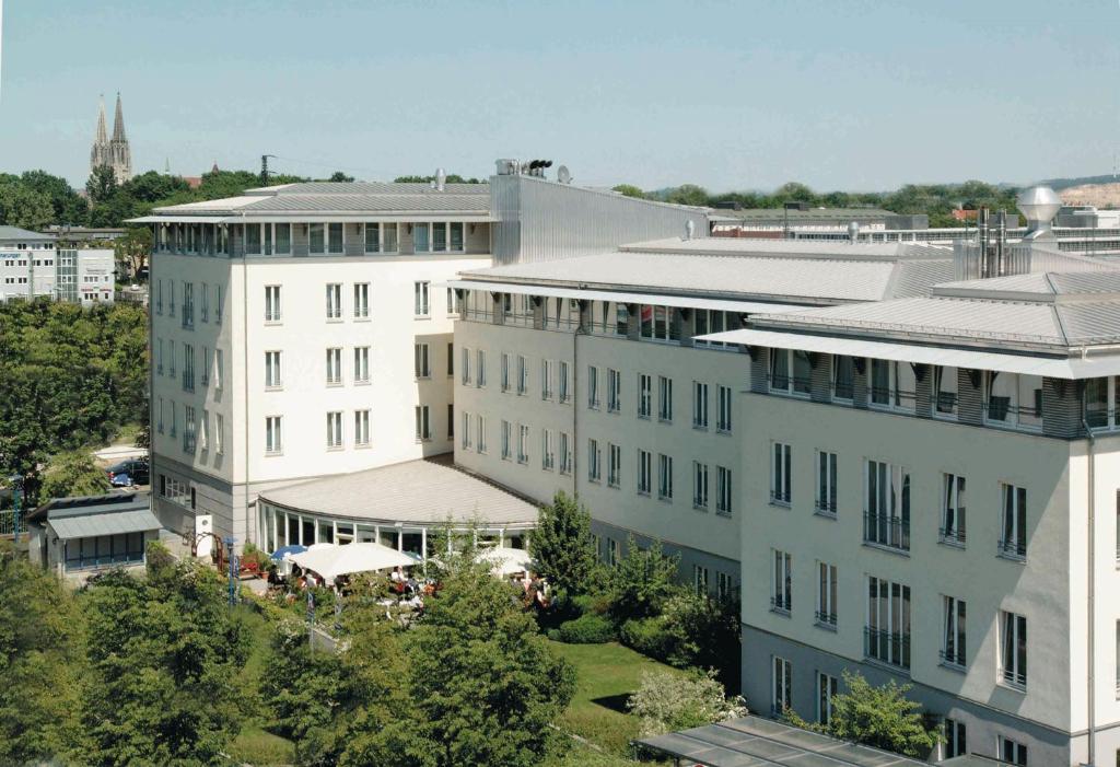 an overhead view of a white building with trees and buildings at Hansa Apart-Hotel Regensburg in Regensburg