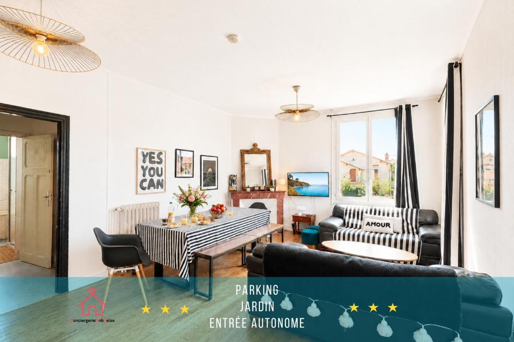 a living room with a couch and a table at " Le Grand Biarritz " Jardin - Parking - WIFI in Toulouse