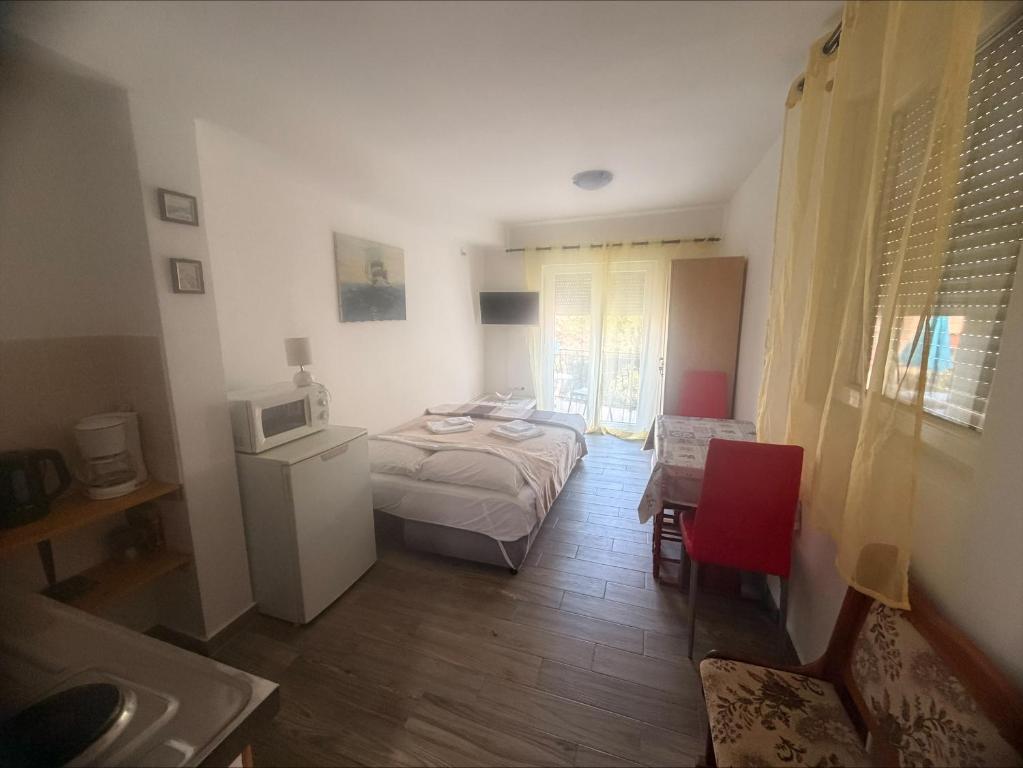 a small bedroom with a bed and a microwave at Adrasteja 3 - apartment Dramalj in Dramalj