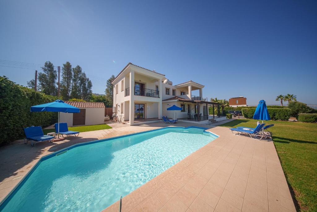 a villa with a swimming pool in front of a house at Ocean Breeze Club-Villa Mare in Kato Yialia