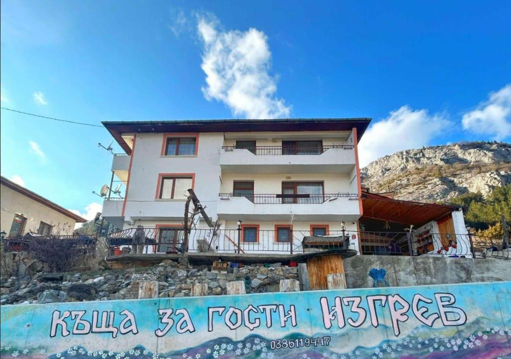 a building on top of a mountain with a sign at Къща за гости Изгрев in Trigrad
