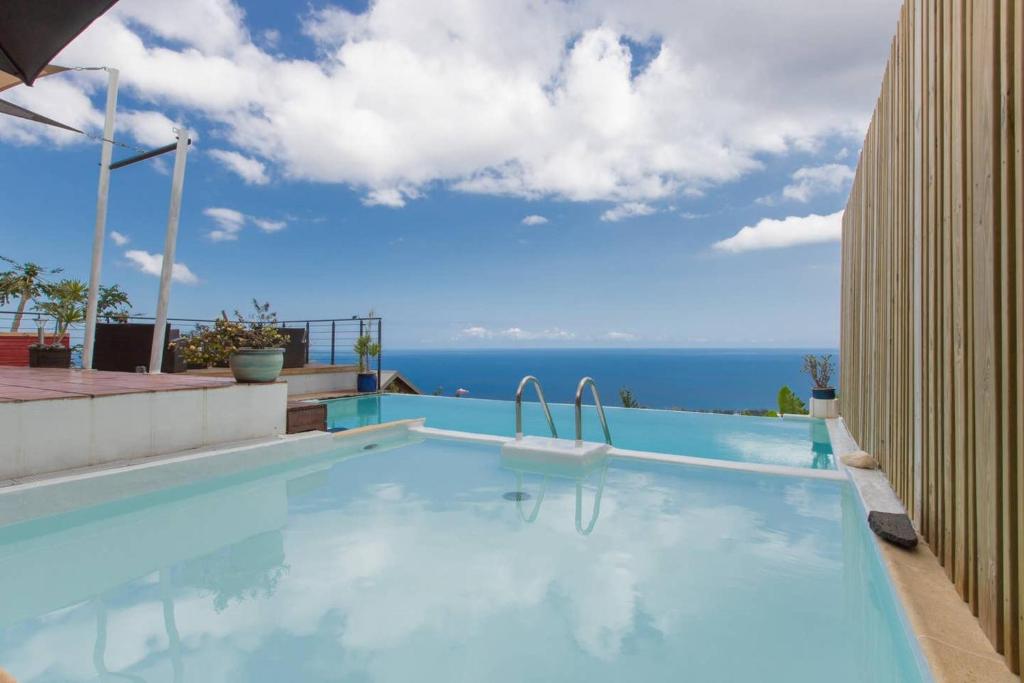 a swimming pool with a view of the ocean at Villa élégante à Saint-Paul avec piscine privée ouverte toute l'année in Saint-Paul