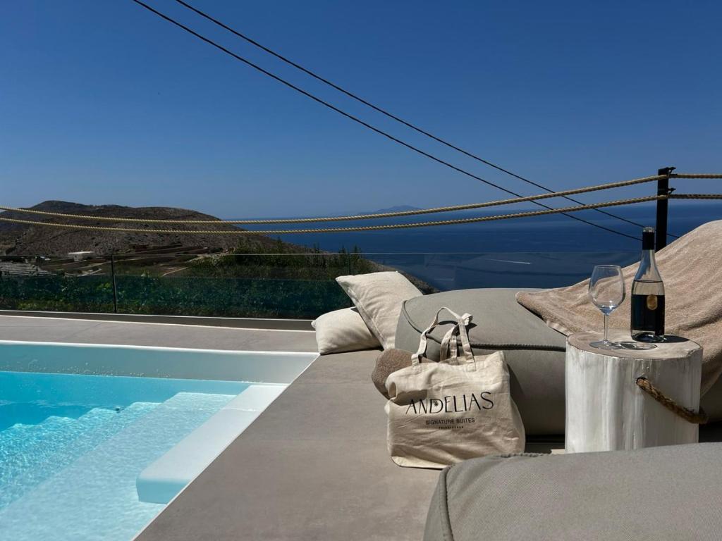 a villa with a pool and a table with wine glasses at ANDELIAS Signature Suites in Chora Folegandros