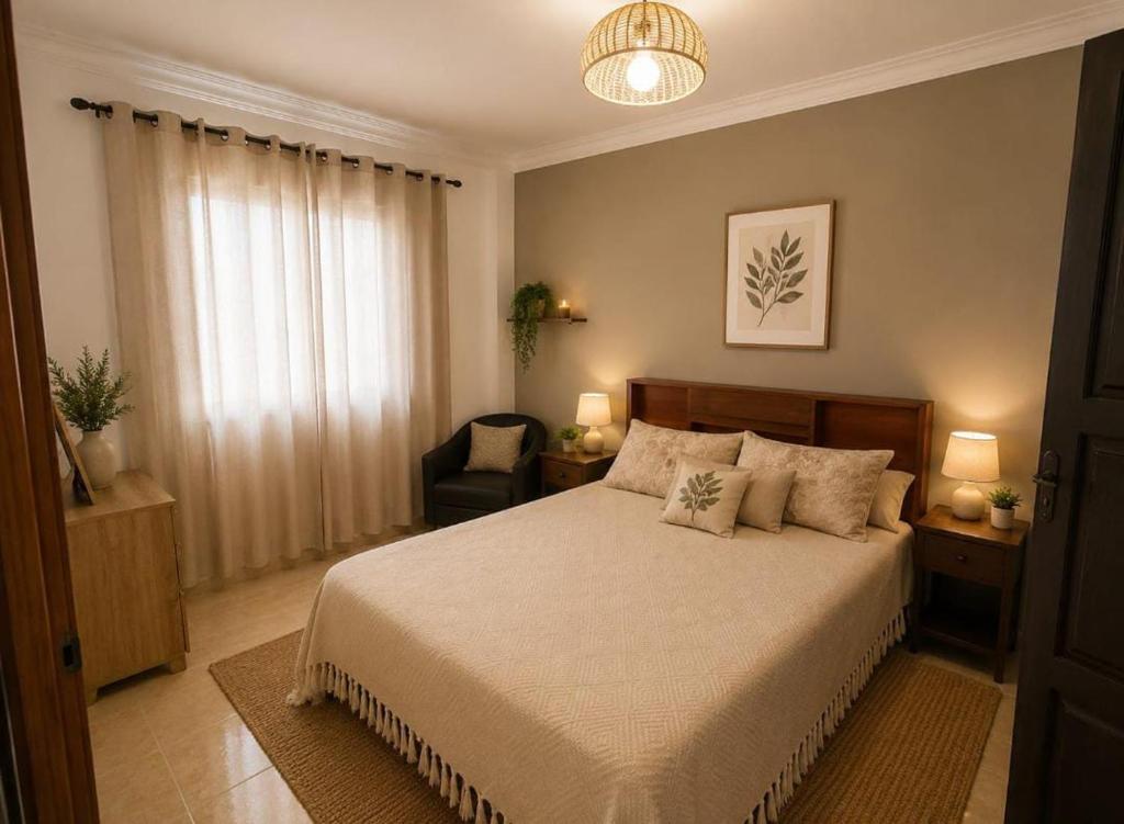 a bedroom with a large bed and a chair at Rayhane-26 in Al Ghar