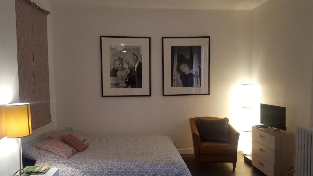 a bedroom with a bed and two pictures on the wall at Charmant Studio à 2pas du Château de Vincennes in Vincennes