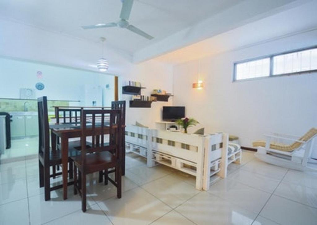 a living room with a table and chairs and a television at Modern Apartment in Pereybere + Pool in Pereybere
