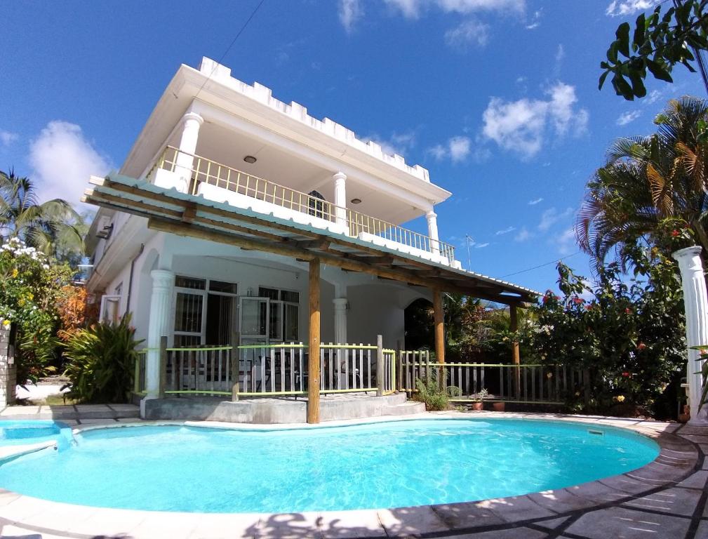 a house with a swimming pool in front of it at Spacious Apartment in Pamplemousses with Private Pool in Pamplemousses Village