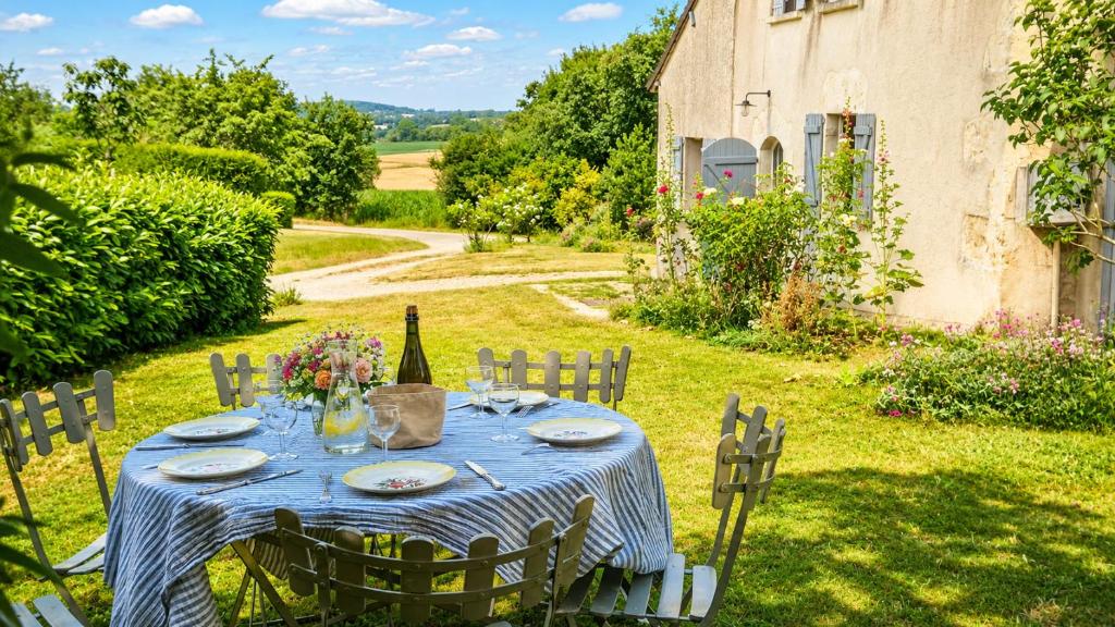 a blue table with a bottle of wine on it at Maison de campagne chaleureuse dans le Perche in Val-au-Perche