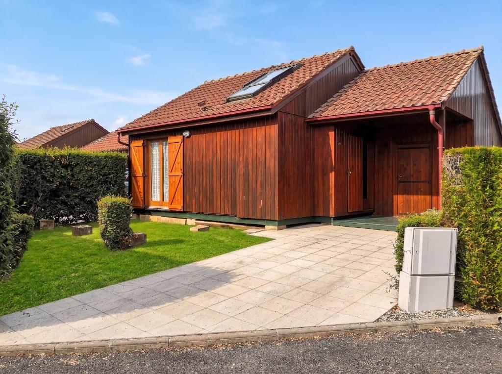 a large wooden house with a patio at Chalet confortable à Giffaumont-Champaubert avec terrasse in Giffaumont-Champaubert