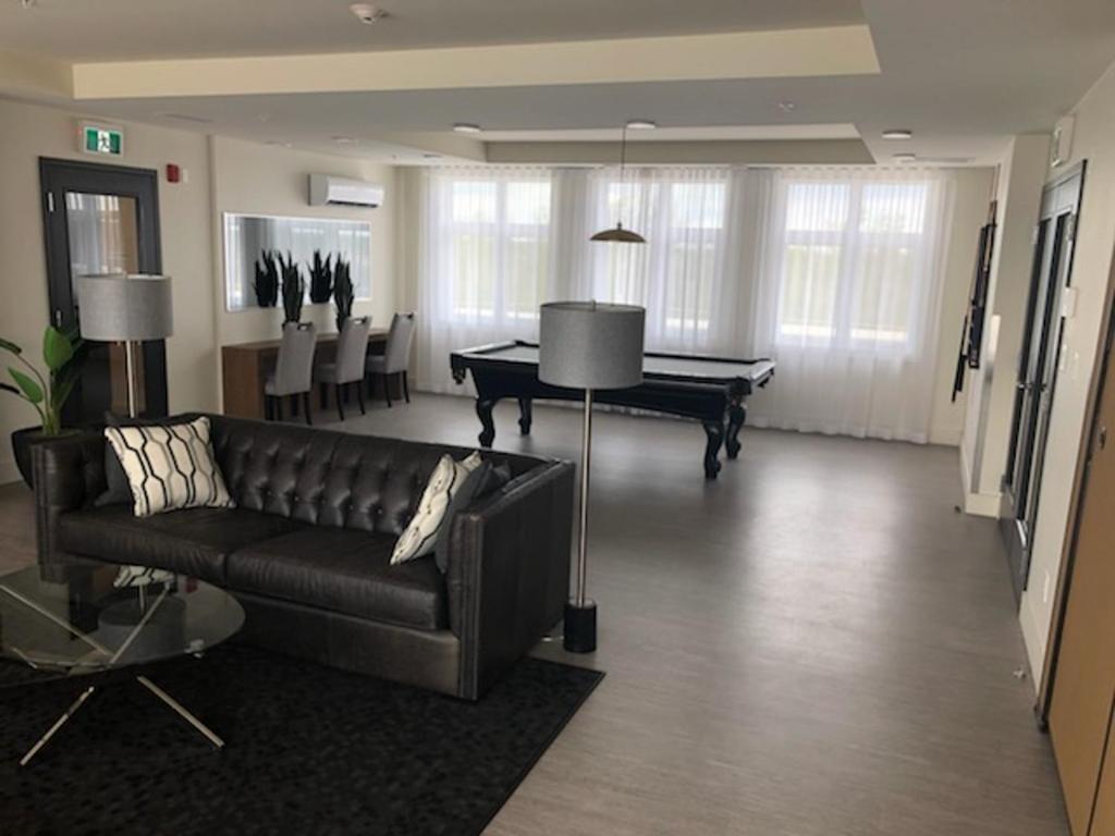 a living room with a couch and a pool table at Luxurious Apartment in Brossard with Terrace in Brossard