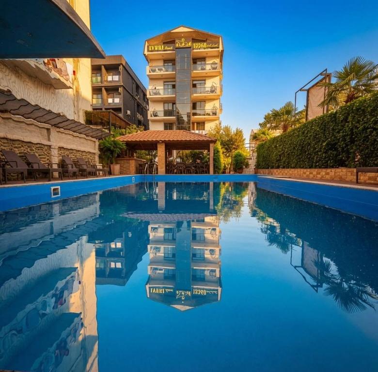 a swimming pool with a building in the background at IVERIA BEACH in Kobuleti