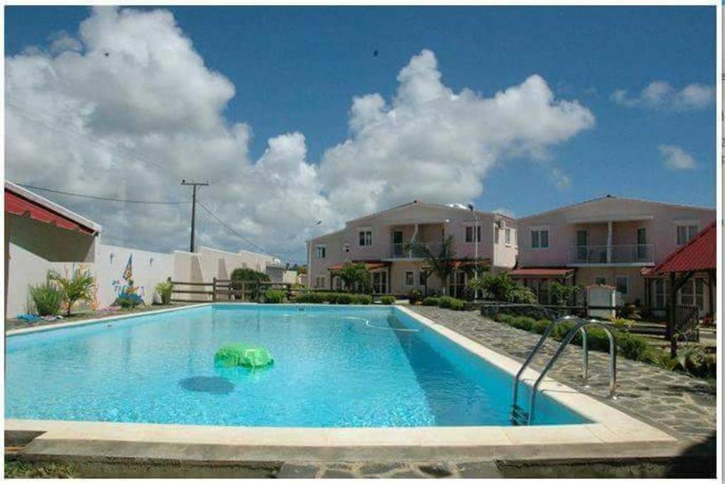 a swimming pool in front of some houses at Modern Apartment in Melville, Pool View, 120 m² in Grande Gaube