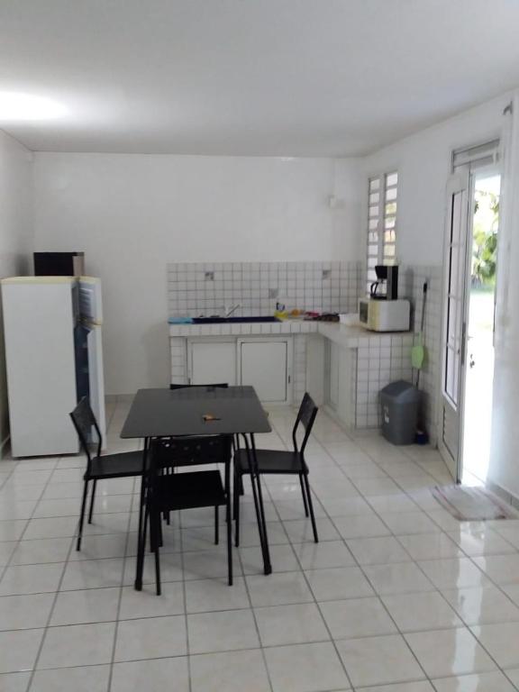 a kitchen with a table and chairs and a refrigerator at Maison accueillante aux Mangles avec jardin clôturé in Les Mangles