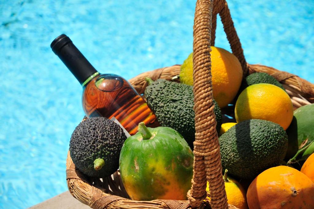 Una cesta con fruta y una botella de vino. en Apartamentos Buen Leon, en Playa de Tasarte