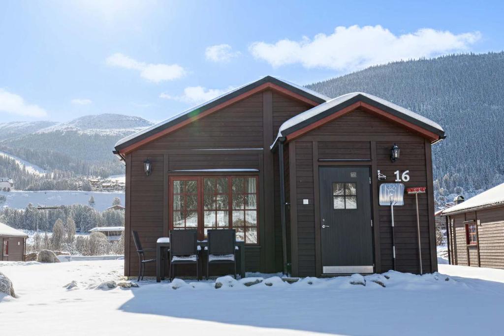 a small cabin with a table and chairs in the snow at Lake Cabin with Fireplace in Åre