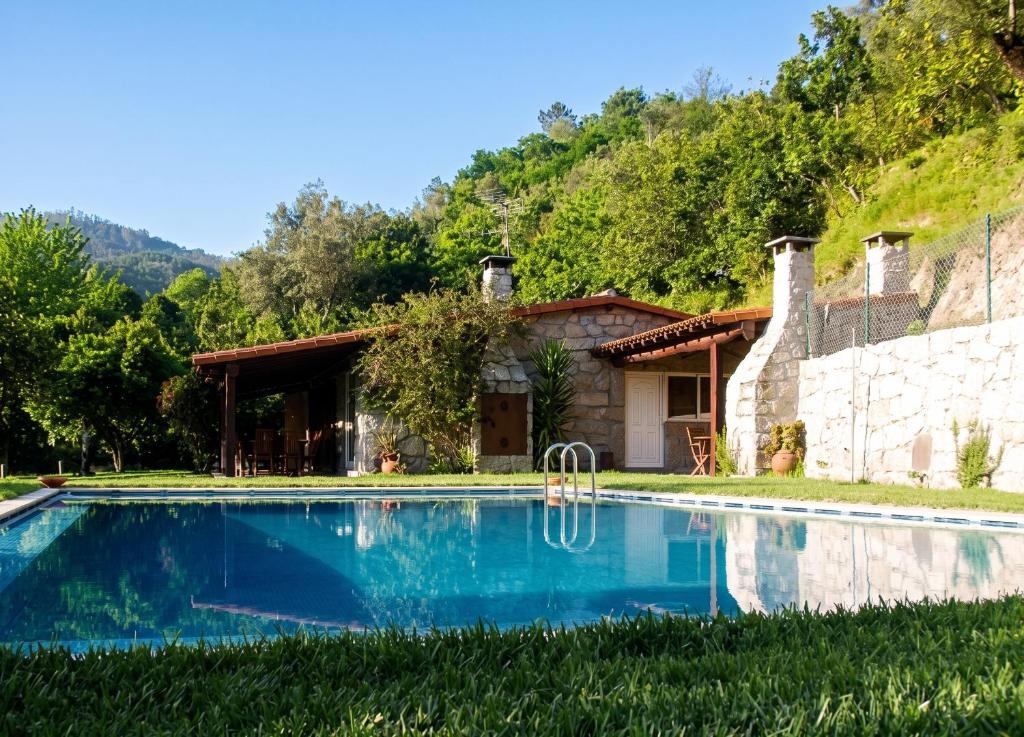 a house with a swimming pool in front of a house at Elegant Villa with Panoramic Views in Caniçada in Caniçada