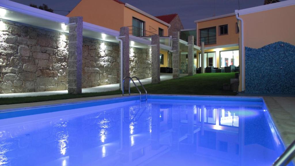 a swimming pool in front of a house at night at Comfortable Bungalow Pinhel, pool in Pinhel