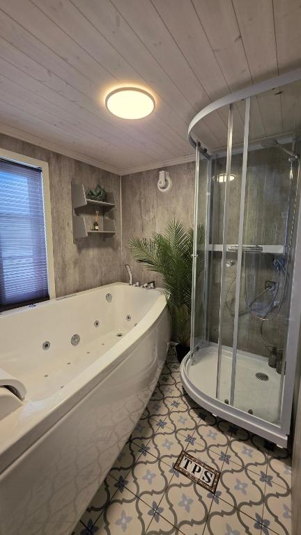 a bathroom with a large tub and a shower at The Perfect Stop - Northern Halo in Lødingen