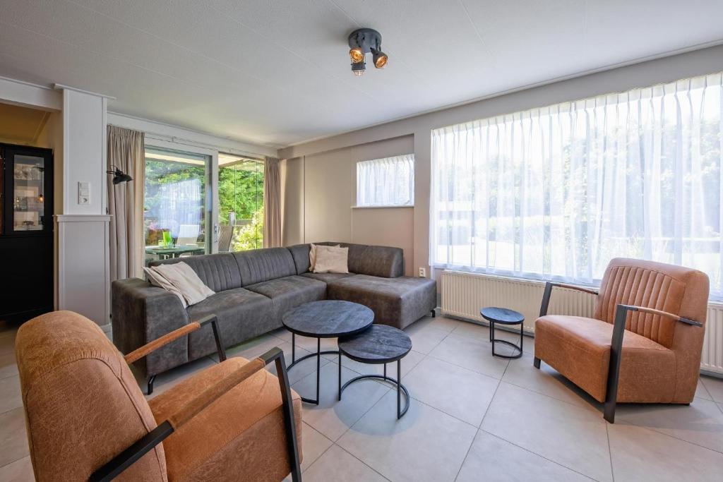 a living room with a couch and a table and chairs at Strandhuys Oester in De Koog