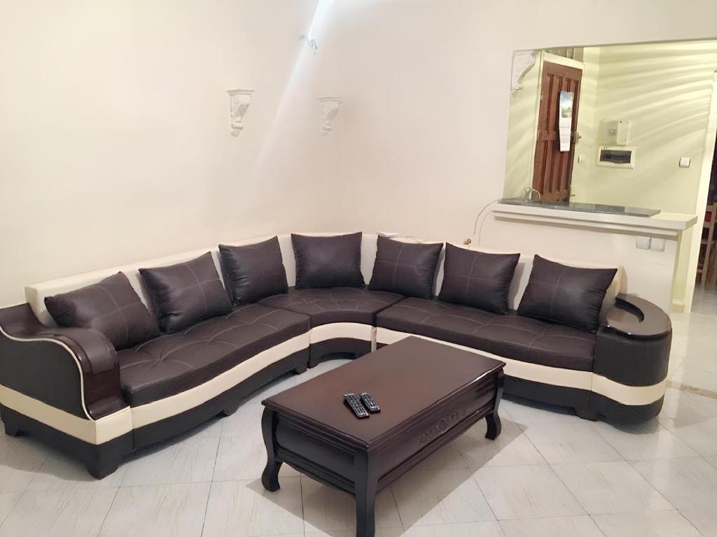 a brown couch in a living room with a table at Stylish apartment in El Marsa 75 m² sea view in El Marsa
