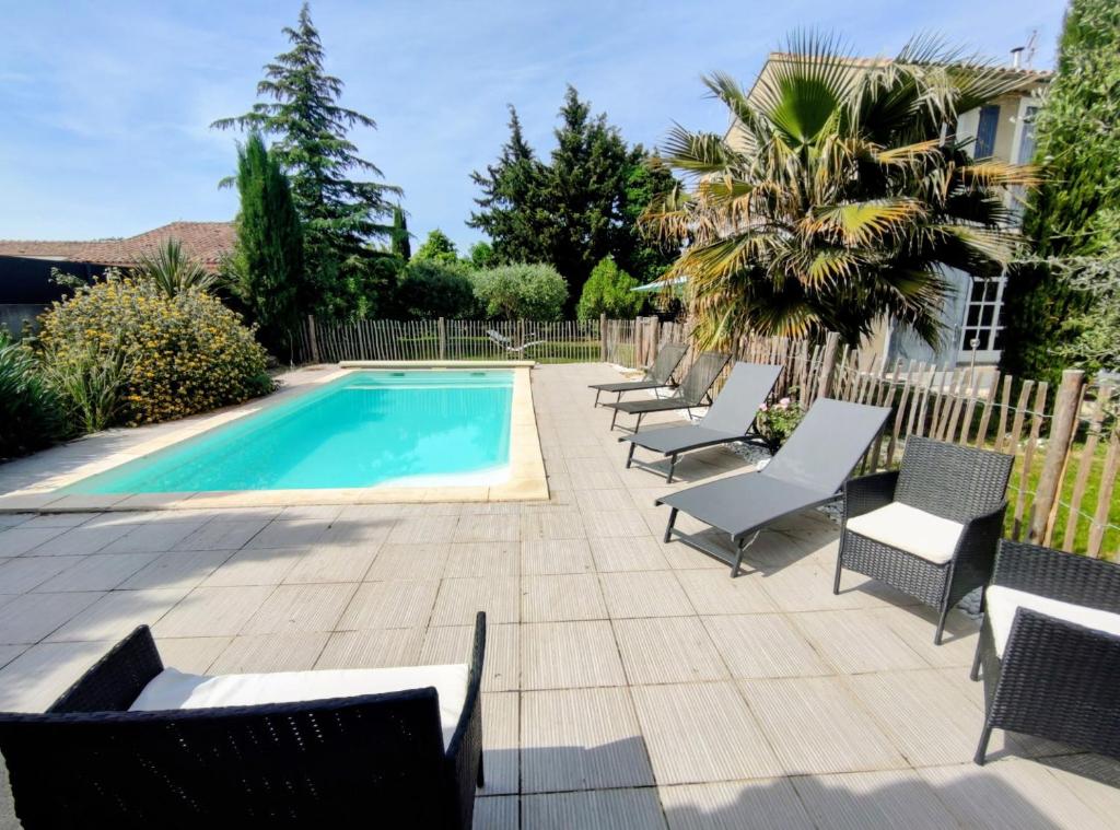 a patio with chairs and a swimming pool at Quiet house, sun and pool in Le Thor