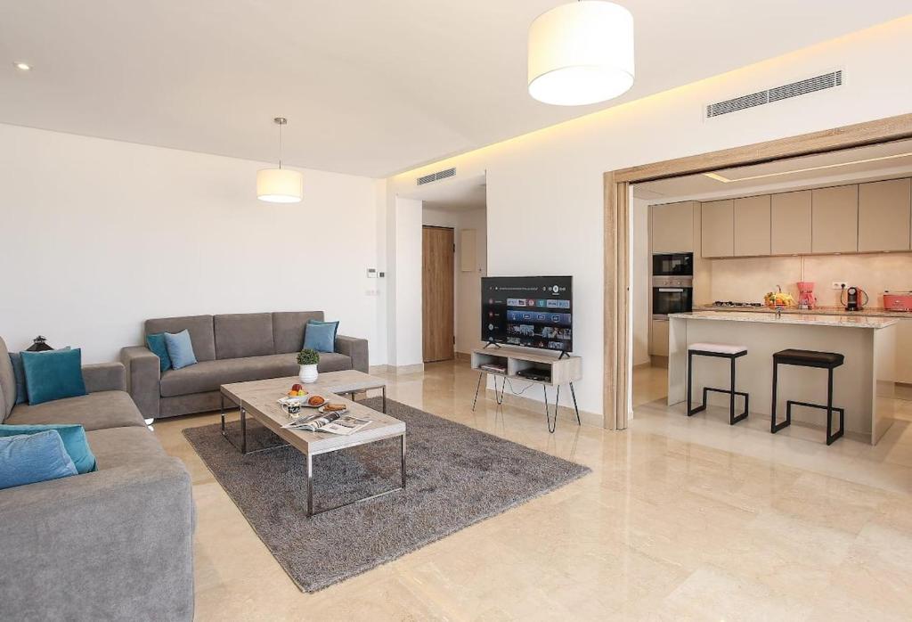 a living room with a couch and a table and a kitchen at La Brise De Gammarth in Gammarth