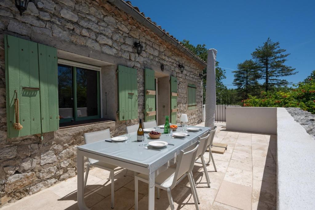a white table and chairs on a patio at Maison Henriette - Authentique maison ardéchoise in Labeaume