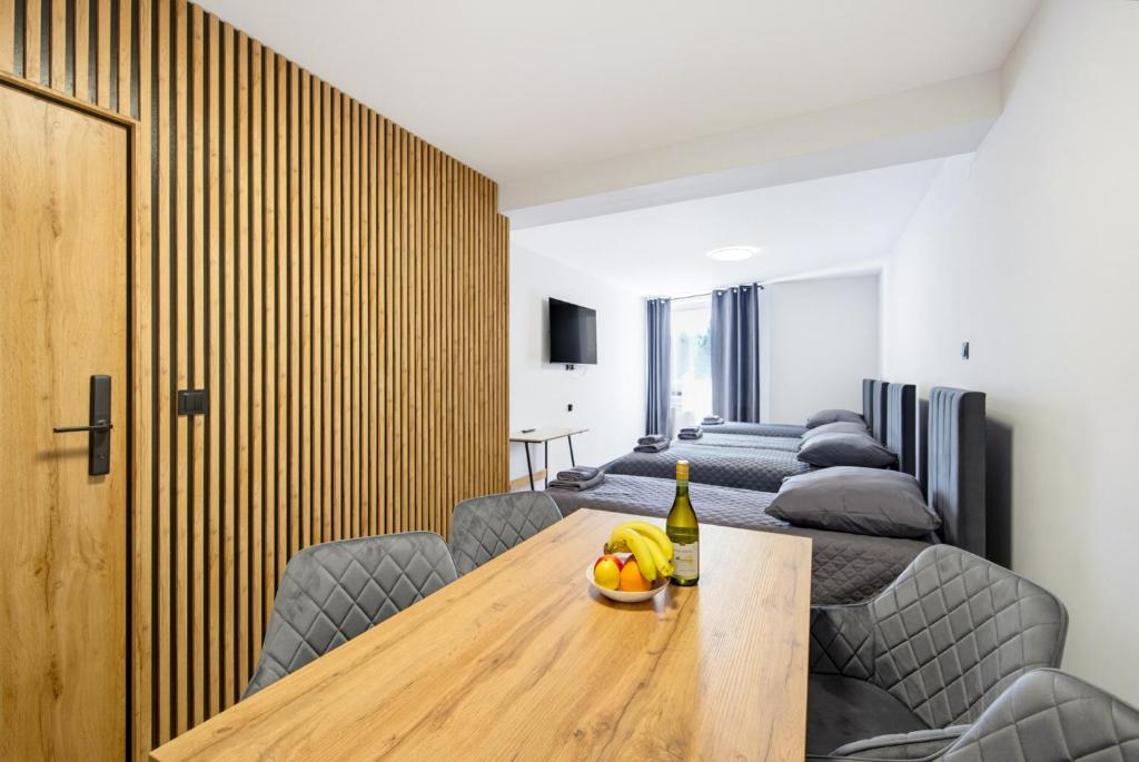 a dining room with a wooden table and chairs at Apartamenty Centrum in Rybnik