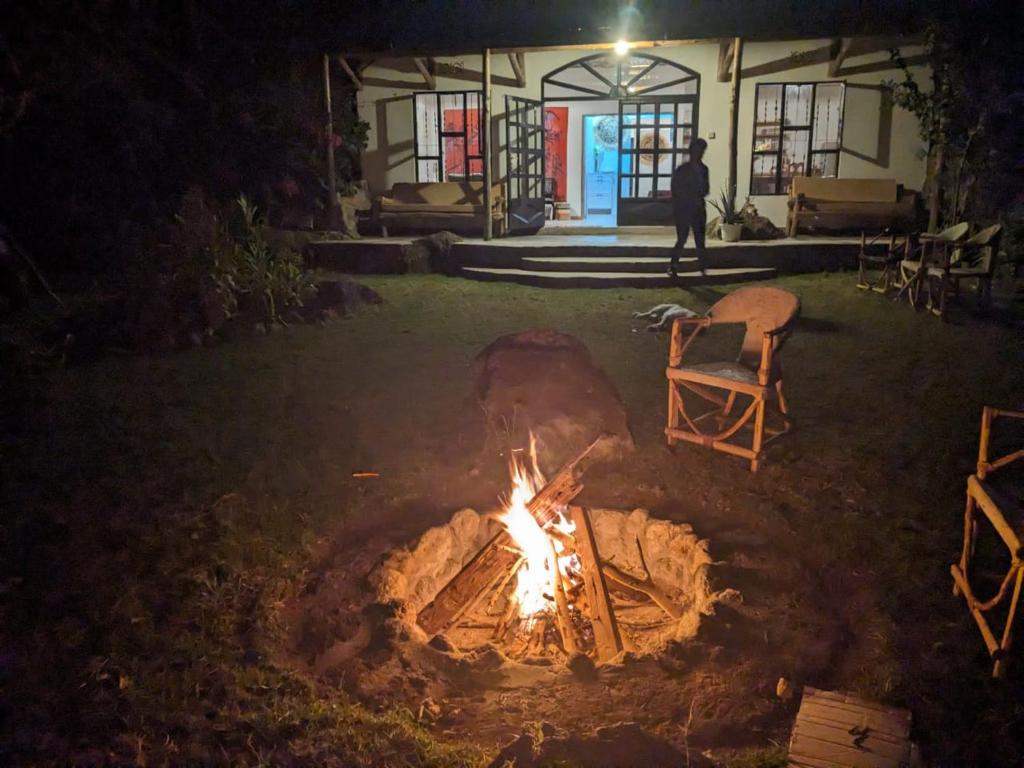 a fire pit in a yard with a person standing in the background at Giraffe Gallery Home in Arusha