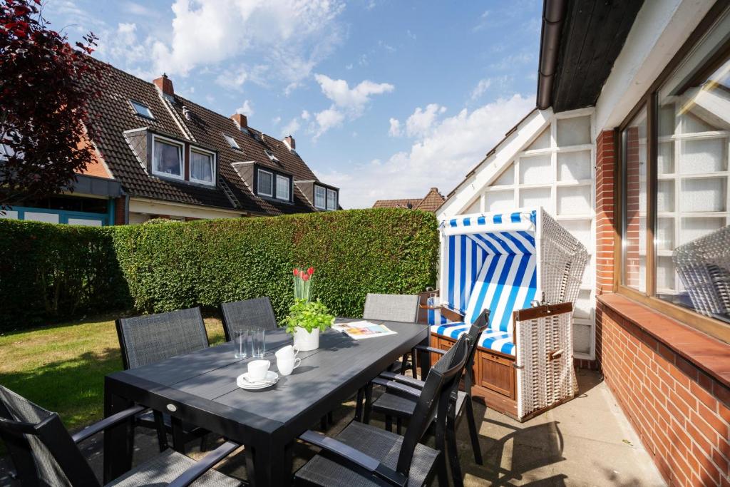 a black table and chairs on a patio with a large blue gate at Sonneneck in Westerland