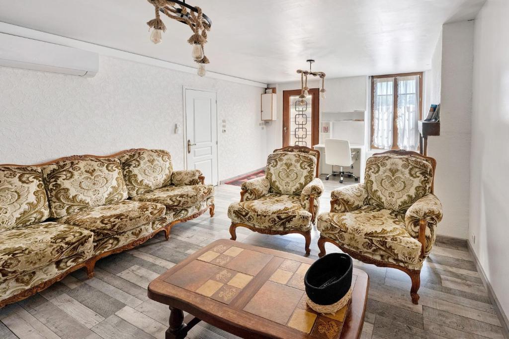 a living room with two couches and a table at Gite grande capacité en Puisaye in Breteau