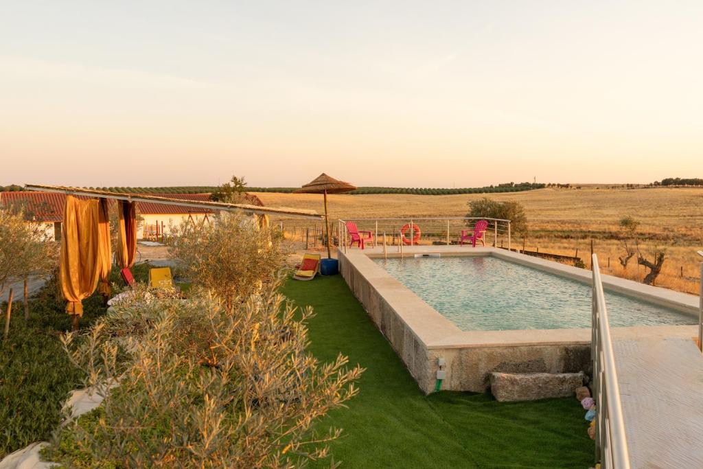 a swimming pool in the middle of a field at Courtyard T0 Studio Farmhouse in Idanha-a-Nova
