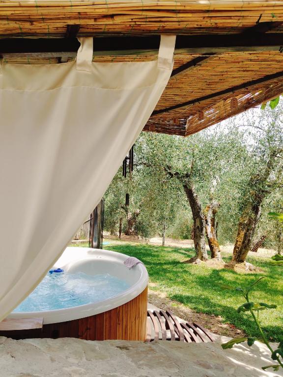 a hot tub in a backyard with a canopy at Cottage La Dolce Agogia Panicale in Panicale