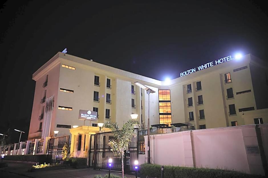 a building with a sign on top of it at night at Bolton White Hotel in Abuja