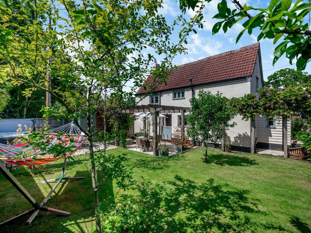 a large white house with a yard with a tree at Hope Cottage in Ilketshall Saint Andrew