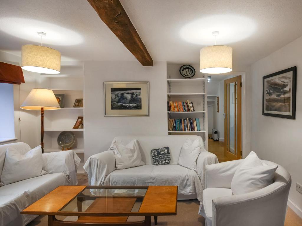 a living room with two white couches and a table at Sheldon Cottage in Bishops Castle